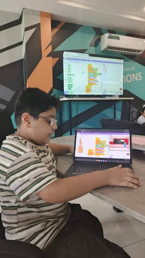 Student coding on a laptop during a STEMForge Python programming workshop
